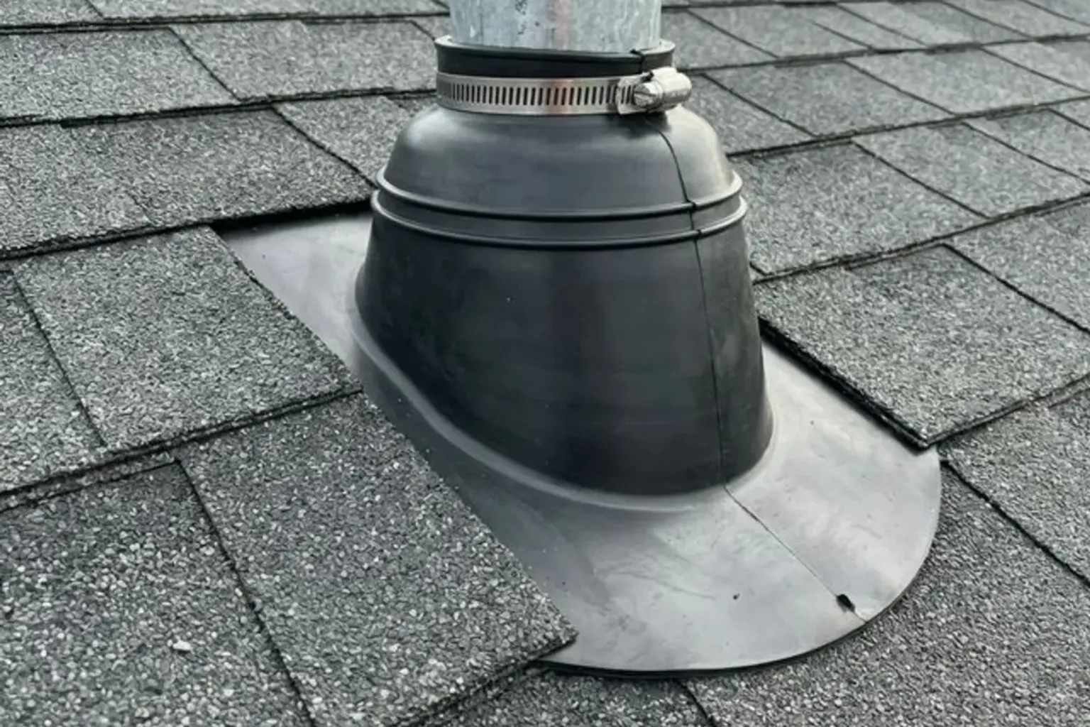 Documentary-style iPhone photo of roofing contractor repairing a residential roof leak in Provo, Utah. Natural lighting.