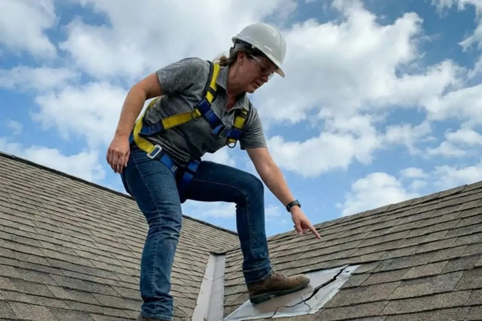Documentary-style iPhone photo of a detailed roof inspection with close-up of shingle condition in Provo, Utah. Natural daylight.